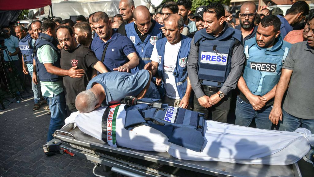palestinian-journalists-in-blue-press-flak-vests-mourn-the-killing-of-a-colleague-by-israeli-forces